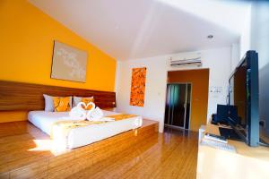 a bedroom with a bed and a flat screen tv at Aurora Resort Kanchanaburi in Kanchanaburi