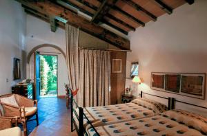 a bedroom with a bed and a chair and a window at Poggetto Masino in Suvereto