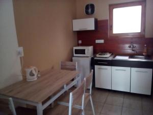a kitchen with a wooden table and a white refrigerator at Ubytovanie Pepo in Štúrovo