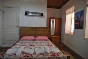 a bedroom with a bed with towels on it at KARABURUN KÖYEVİ Pansiyon in Saip