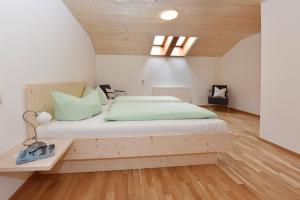 Schlafzimmer mit einem großen Bett mit einem Kopfteil aus Holz in der Unterkunft Hof im Feld in Schruns-Tschagguns