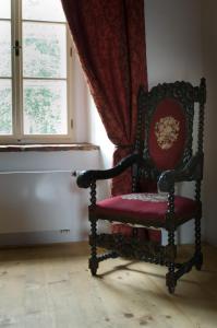 a red chair sitting in a room with a window at Zamek Zabreh in Ostrava