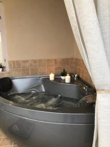 Una bañera con dos velas en un baño. en Mommy's House, en Angeliana