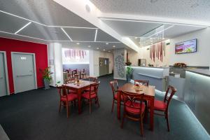 a restaurant with tables and chairs and a kitchen at Hotel Villa Eden in Jihlava