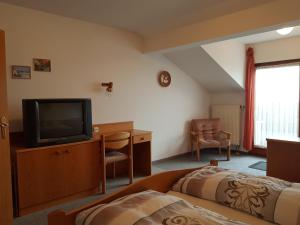 a hotel room with a tv and a bed at Monteurunterkunft Haus Max & Moritz in Böbrach
