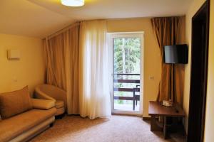 - un salon avec un canapé et une fenêtre dans l'établissement Hotel Crisalpin, à Poiana Brasov