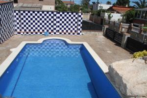 a blue swimming pool with a checkeredkered at Chalet con piscina privada en zona tranquila de Cambrils in Cambrils