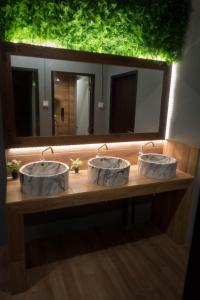 a bathroom with three sinks in front of a mirror at Comfy Bed Hostel in Bangkok