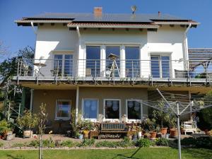 a large white house with a balcony at Ferienwohnung Dr. Vera Schmidt in Kreischa