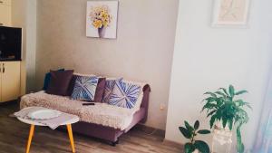 a living room with a couch and a table at Here comes the sun in Batumi