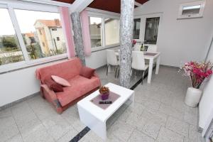 a living room with a red couch and a table at Apartments Divna in Rovinj