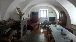 - un salon avec une table et une cheminée dans l'établissement Kovářův mlýn, à Stachy