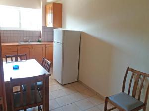 een keuken met een witte koelkast en een tafel en stoelen bij Ζante Dolphin in Alykes