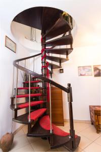 a spiral staircase in a house with red carpet at Villa Efi in Skala Rachoniou