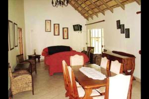 a living room with a red couch and a table at Mothopo Game Lodge in Modimolle +8 photos