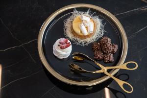 a plate of desserts with a pair of scissors at Porto Platanias Beach Luxury Selection - Adults Only in Plataniás