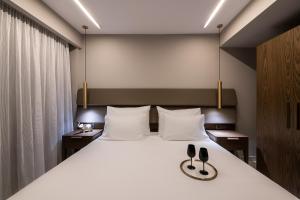 a bedroom with a large bed with two shoes on it at Porto Platanias Beach Luxury Selection - Adults Only in Plataniás