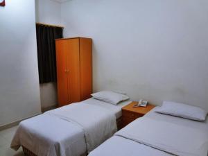 una camera con 2 letti e un armadio in legno di Plaza Hotel a Mascate