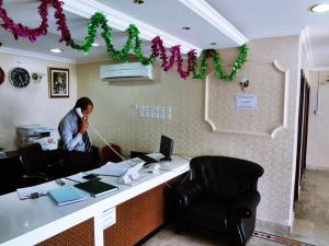 Een man die aan het bellen is in een kantoor. bij Plaza Hotel in Muscat