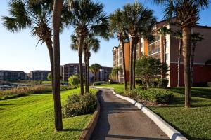un sentiero fiancheggiato da palme di fronte a un edificio di Westgate Lakes Resort and Spa a Orlando