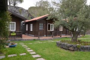 a log cabin with a tree in the yard at Etna Hut in Nicolosi