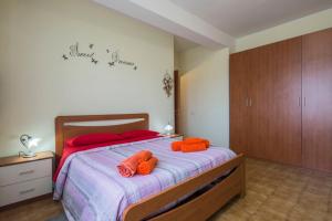 een slaapkamer met een bed met 2 oranje handdoeken erop bij Il cipresso in Salerno