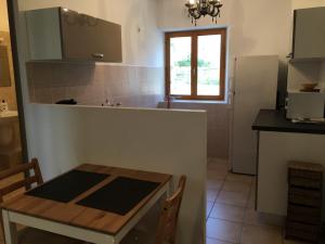 a kitchen with a table and a small table and a table and a refrigerator at Le Chardon 2 in Baudinard