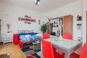 uma sala de estar com uma mesa e cadeiras vermelhas em Il cipresso em Salerno