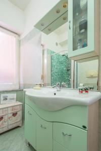 uma casa de banho com um lavatório e um espelho grande em Il cipresso em Salerno