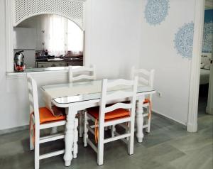 - une table et des chaises blanches dans la cuisine dans l'établissement Novo Paradise, à Chiclana de la Frontera