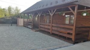 a wooden building with a pavilion on a brick sidewalk at Сонечко in Velyka Bihanʼ