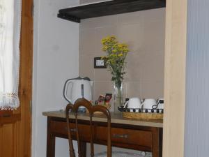eine Küchentheke mit einem Tisch und einer Blumenvase in der Unterkunft B&B Ca' Morino in Novaglie