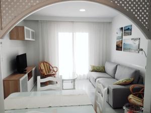 a living room with a couch and a tv at Novo Paradise in Chiclana de la Frontera