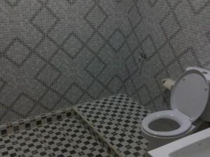 a bathroom with a toilet and a checkered floor at Agung Trisna Bungalows in Ubud +17 photos