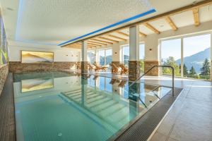 a swimming pool in a house with a mountain at Gasthof Almhof in Oberau