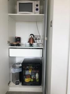 a small kitchen with a stove and a microwave at The Bungalows Guesthouse in Threlkeld