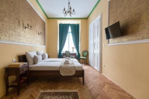 a bedroom with a bed with a television and a window at Barbo Palace Apartments and Rooms in Ljubljana