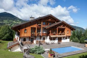 uma casa grande com uma piscina em frente em Le Cerf Amoureux Chalet Privé & Spa em Sallanches