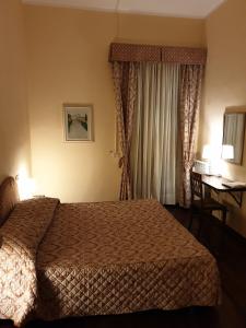 Pokój hotelowy z łóżkiem i biurkiem z biurkiem w obiekcie Affittacamere Mazzini 78 w mieście Grosseto