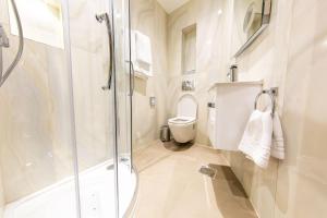a bathroom with a shower and a toilet at The Crescent Hyde Park in London