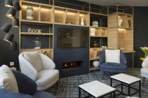 a living room with a couch and a fireplace at Odalys City Le Mans Centre Congrès in Le Mans
