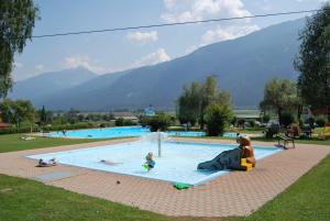 a group of people playing in a swimming pool at Haus Fischer Nassfeldblick in Kirchbach