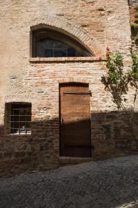 un edificio de ladrillo con una puerta en el costado en Palazzo d'Assi - Guest house en Monforte dʼAlba