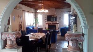 een eetkamer met een tafel en blauwe stoelen bij Paradise House in Liapades