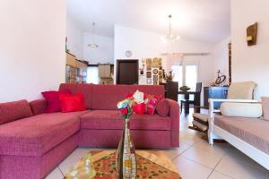 sala de estar con sofá púrpura y jarrón con flores en Villa Efi en Skala Rachoniou