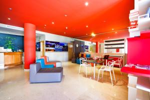 a living room with an orange ceiling and a table and chairs at Aparthotel Autosole in Estepona