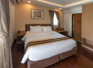 a bedroom with a large bed with white sheets at Stable Lodge - SHA Certified in Bangkok +45 photos