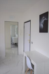 um quarto branco com uma secretária branca e uma casa de banho em Uni Apart em Trento