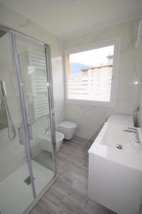 een badkamer met een douche, een wastafel en een toilet bij Uni Apart in Trento