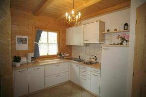 a kitchen with white cabinets and a sink and a window at Ferienhaus Aussergraben in Ultimo